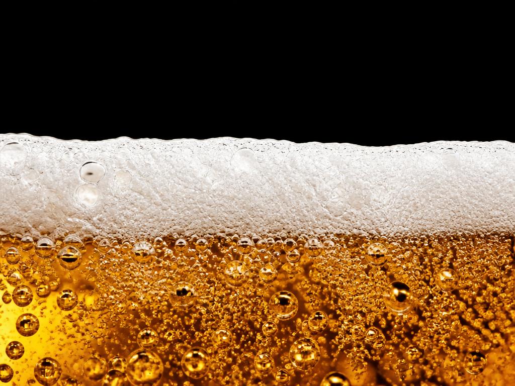 Close macro de cerveja com espuma cremosa